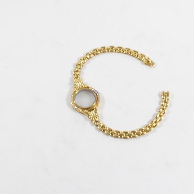 une photo d'un bracelet à chaîne en or orné d'une pierre blanche au centre