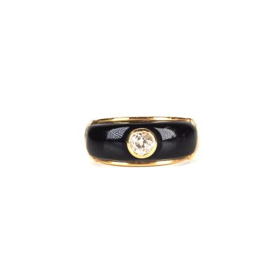 une photo d'une bague noire et dorée sertie d'un diamant blanc