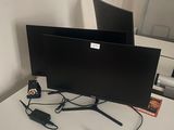 deux écrans posés sur un bureau, avec une souris et un clavier