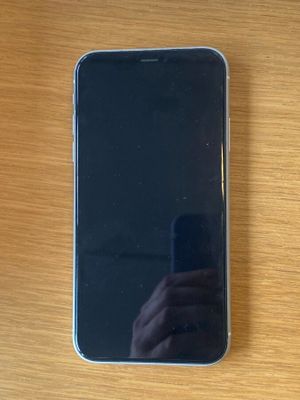 Quelqu'un prend une photo de son téléphone portable posé sur une table en bois.