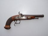 an old gun with a wooden handle on a white surface