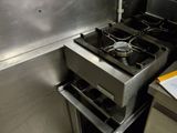 une cuisine équipée d'une cuisinière et de casseroles accrochées au mur