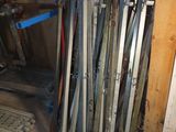 a pile of skis and ski poles in a room