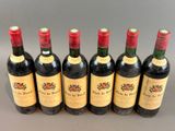 six bottles of wine lined up in a row on a table