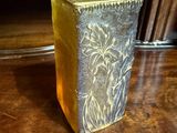 a gold vase sitting on a wooden table with a price tag on it