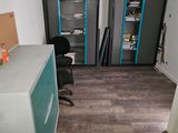 a room with a desk, shelves and a chair in it