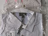 two men ' s shirts wrapped in plastic on top of each other