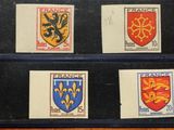 quatre timbres représentant différents blasons, posés sur une table