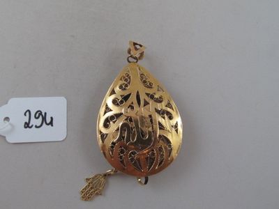 a gold pendant with a leaf on it next to a price tag