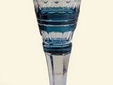 un verre à vin bleu posé sur une table blanche