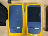 two yellow and black cell phones sitting next to each other on a table