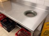 a sink in the middle of a stainless steel counter