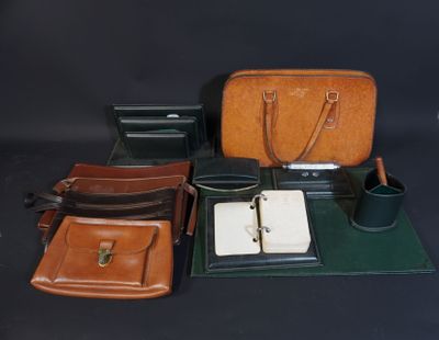 several pieces of leather are sitting on a table with a pen and a bag