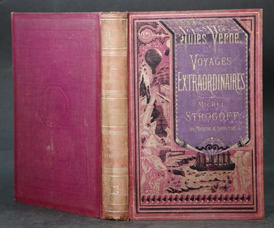 un vieux livre à la couverture rose posé sur une table