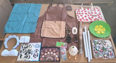 une table sur laquelle se trouvent de nombreux objets, notamment un tablier, un saladier, une assiette et d'autres objets