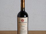 a bottle of red wine sitting on a wooden table