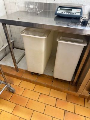 une photo d'une cuisine avec deux poubelles et un grille-pain