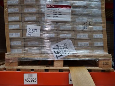 une palette remplie de cartons, placée sur une autre palette dans un entrepôt