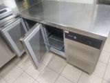 un plan de travail en acier inoxydable avec une porte ouverte dans une cuisine