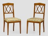 two wooden chairs with upholstered upholstered backs and a patterned upholstered seat