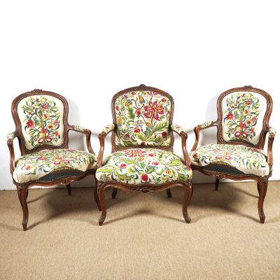 Trois chaises dotées de coussins rembourrés à motifs floraux sont posées sur un sol recouvert de moquette