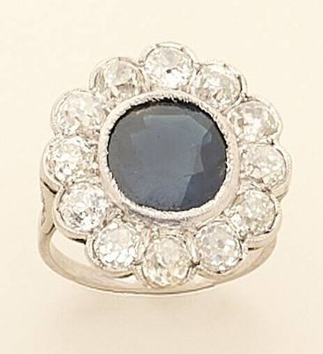 an image of a ring with a blue stone surrounded by white diamonds