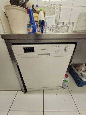 a white dishwasher sitting in a kitchen next to a sink