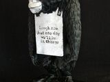 statue of a monkey holding a sign with a sign on it ' s head