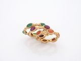 gros plan d'une bague en or avec des pierres multicolores