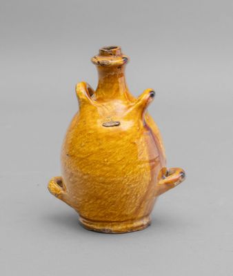 an image of a yellow vase sitting on top of a table