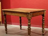 a small table with a wooden top on a carpeted floor