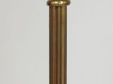 a close up of a lamp on a table with a white wall in the background