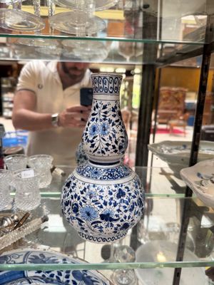 a blue and white vase on display in a glass case