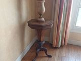 une petite table sur laquelle est posée une lampe, dans un coin de la pièce