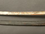 an old dagger with a metal handle on a black surface