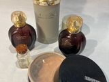 trois flacons de parfum et un pot de poudre posés sur une table