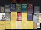 several books on a table with a clock and a clock in the background