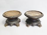 pair of antique bronze candlesticks on pedestals on a white background