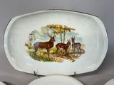 a plate with a picture of a deer and other animals on it