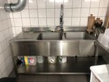 a stainless steel sink in the middle of a kitchen