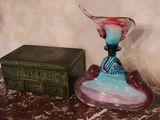 a glass vase sitting on top of a table next to a box