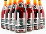 six bottles of wine are lined up in a row on a white surface