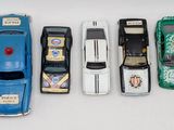 several toy cars are lined up in a row on a white surface