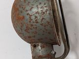 a rusted metal lamp on a wall with a white background