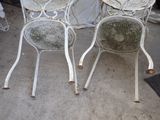 two chairs and a table that are sitting on the ground