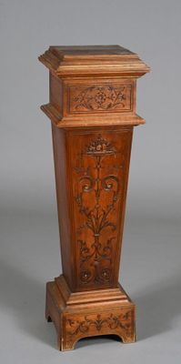 two tall wooden pedestals with carvings on them
