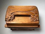 carved wooden box with a bird on it on a white surface