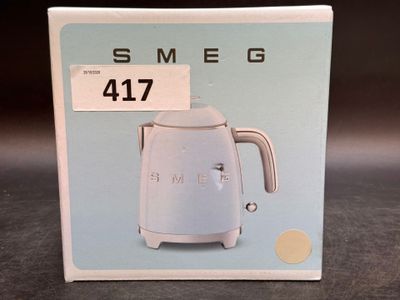 packaging of a blue and white electric kettle sitting on a table