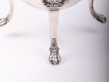 a silver bowl on a stand with a wooden handle