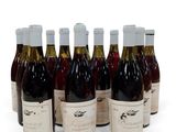 six bouteilles de vin sont alignées sur une surface blanche